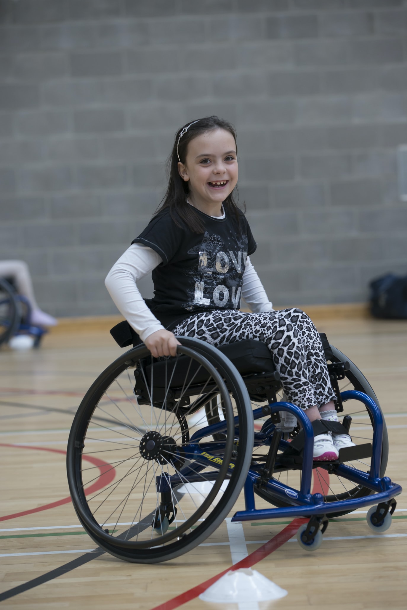 young girl sitting in a lightweight wheelchair